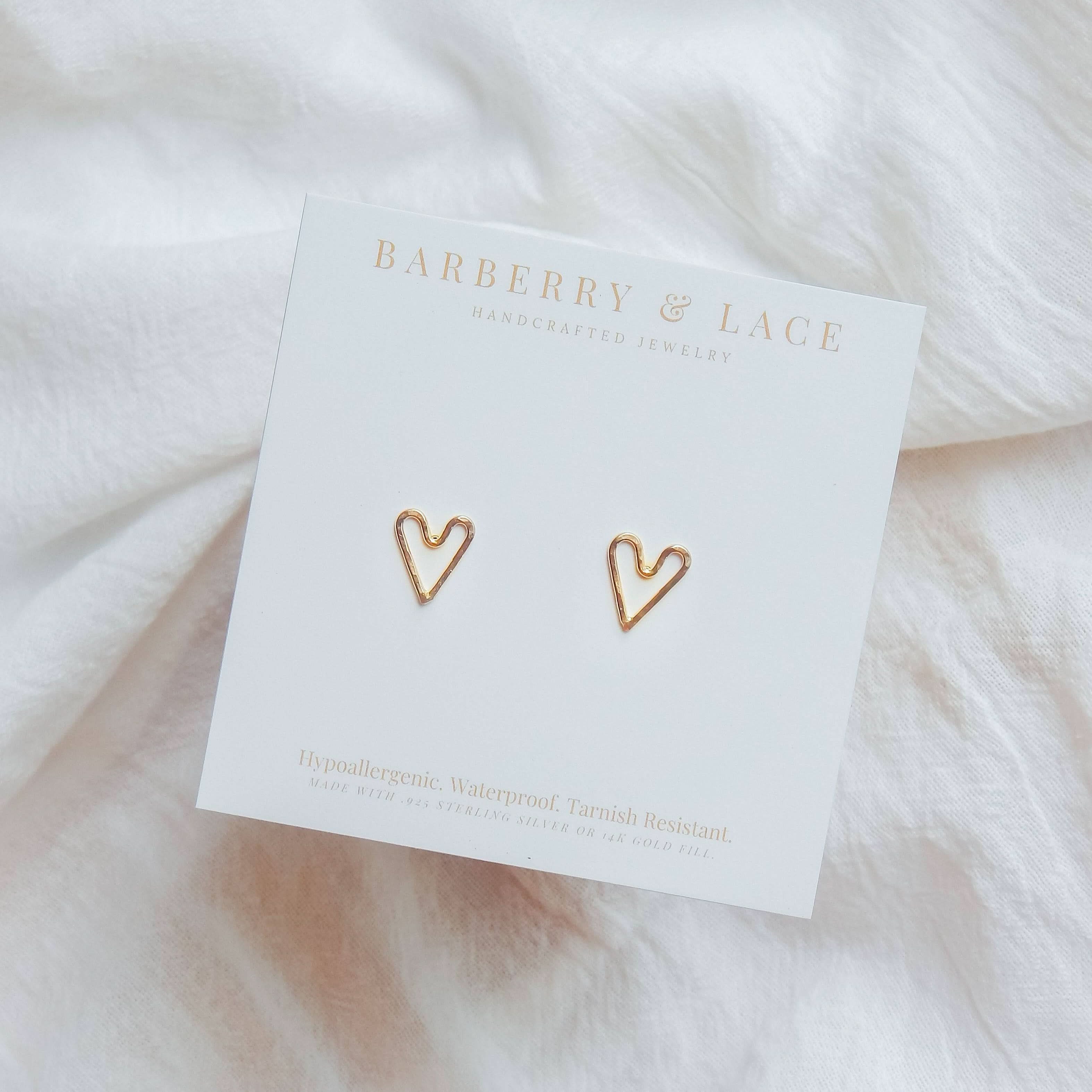 Hammered Heart Stud Earrings displayed on branded Barberry & Lace Jewelry card, highlighting hypoallergenic and waterproof features.