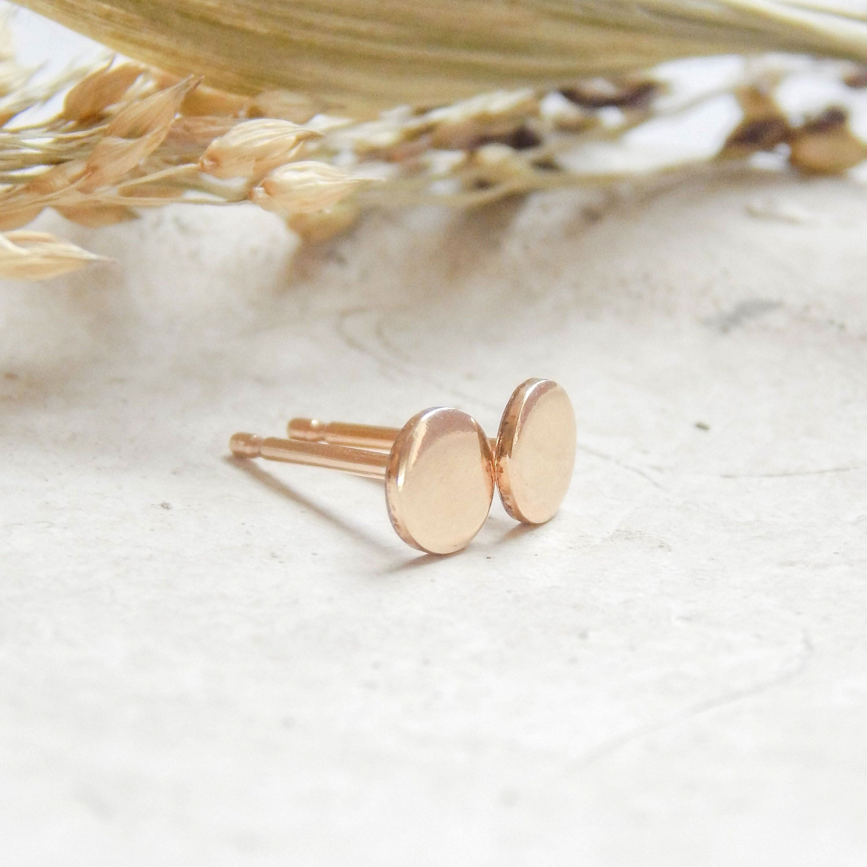 Tiny Dot Circle Stud Earrings in 14k Gold Fill shown on a neutral stone background, minimalist and perfect for everyday wear.