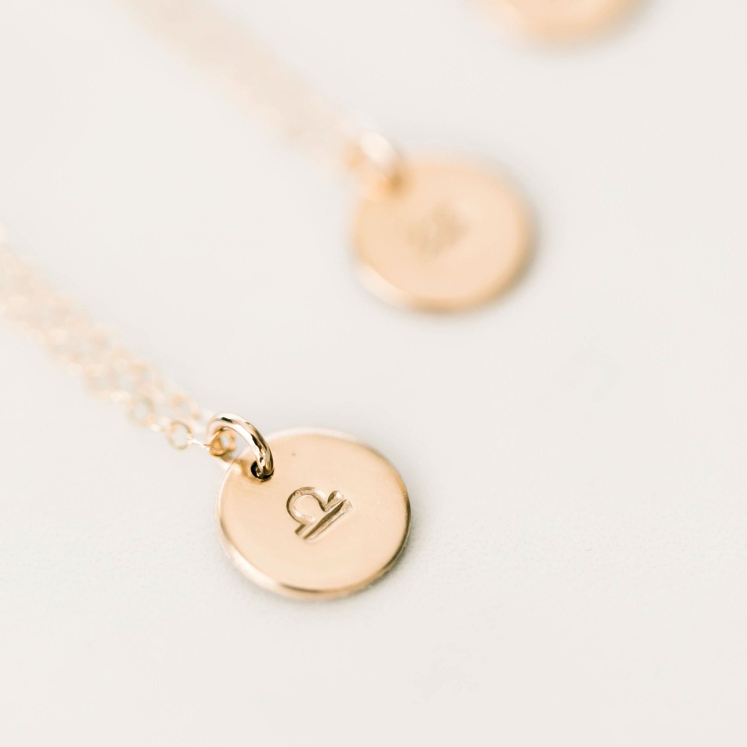 Close-up of Personalized Zodiac Disc Necklace with Libra symbol in gold fill, part of Barberry & Lace Jewelry's celestial collection.