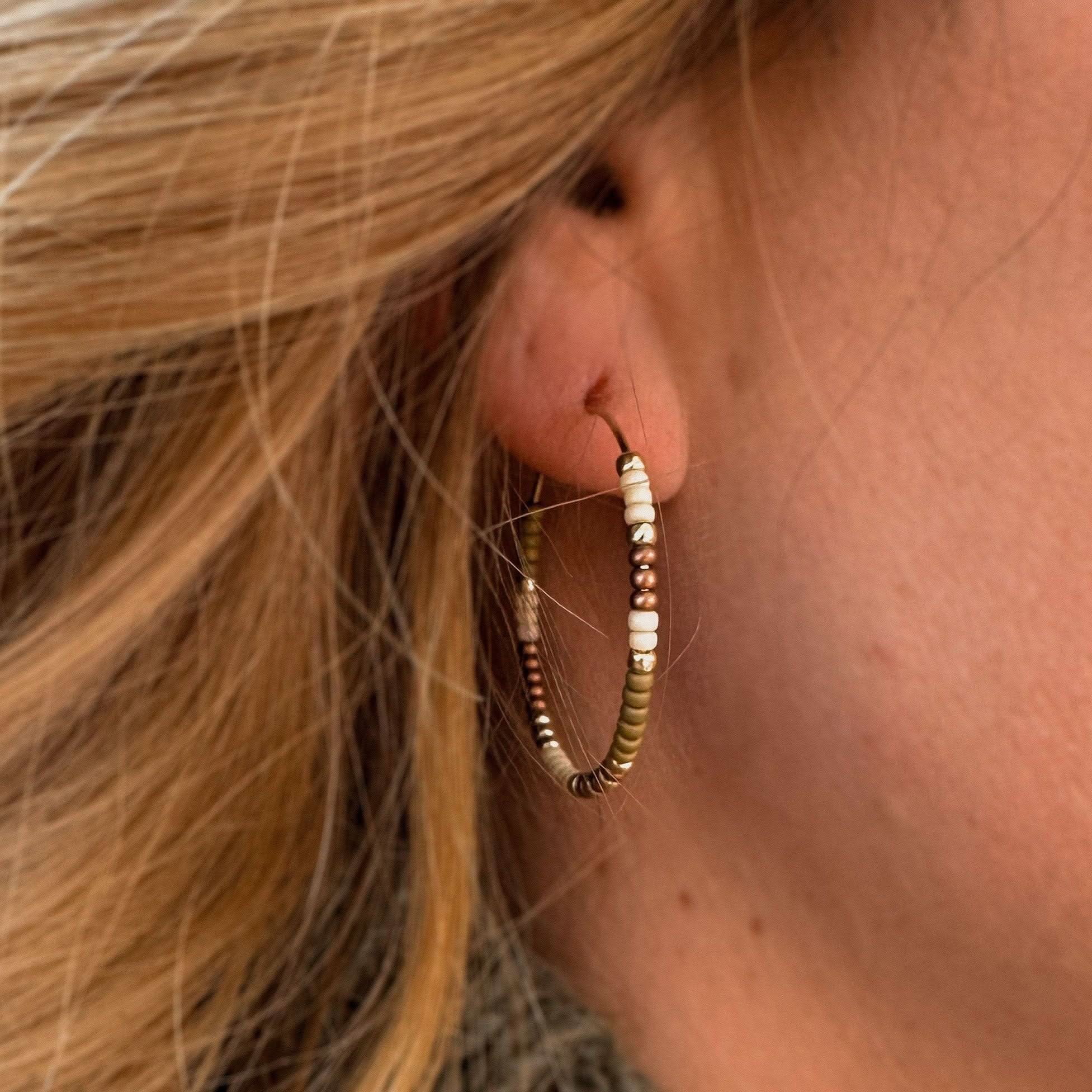 Close-up of Fall Edition - Beaded Hoop Earrings worn on ear, showcasing warm-toned beads in a cozy seasonal style by Barberry & Lace Jewelry.
