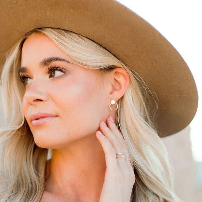 Soleil Stud Earrings worn by model with wide-brim hat, highlighting their timeless gold finish and modern circular silhouette by Barberry & Lace Jewelry.
