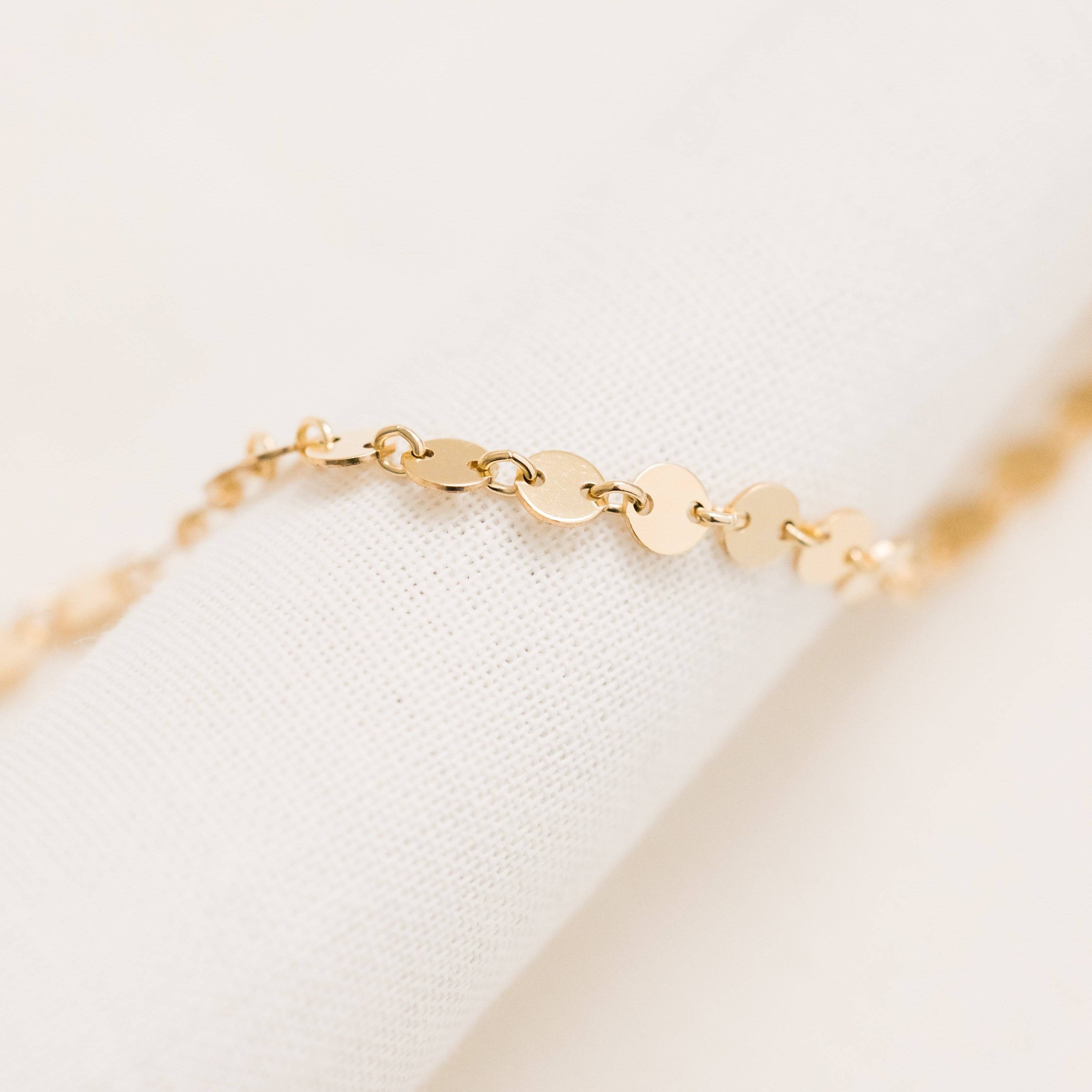 Close-up of Barberry & Lace Disc Chain Bracelet in 14k Gold Fill featuring delicate flat discs linked in a shimmering chain design.