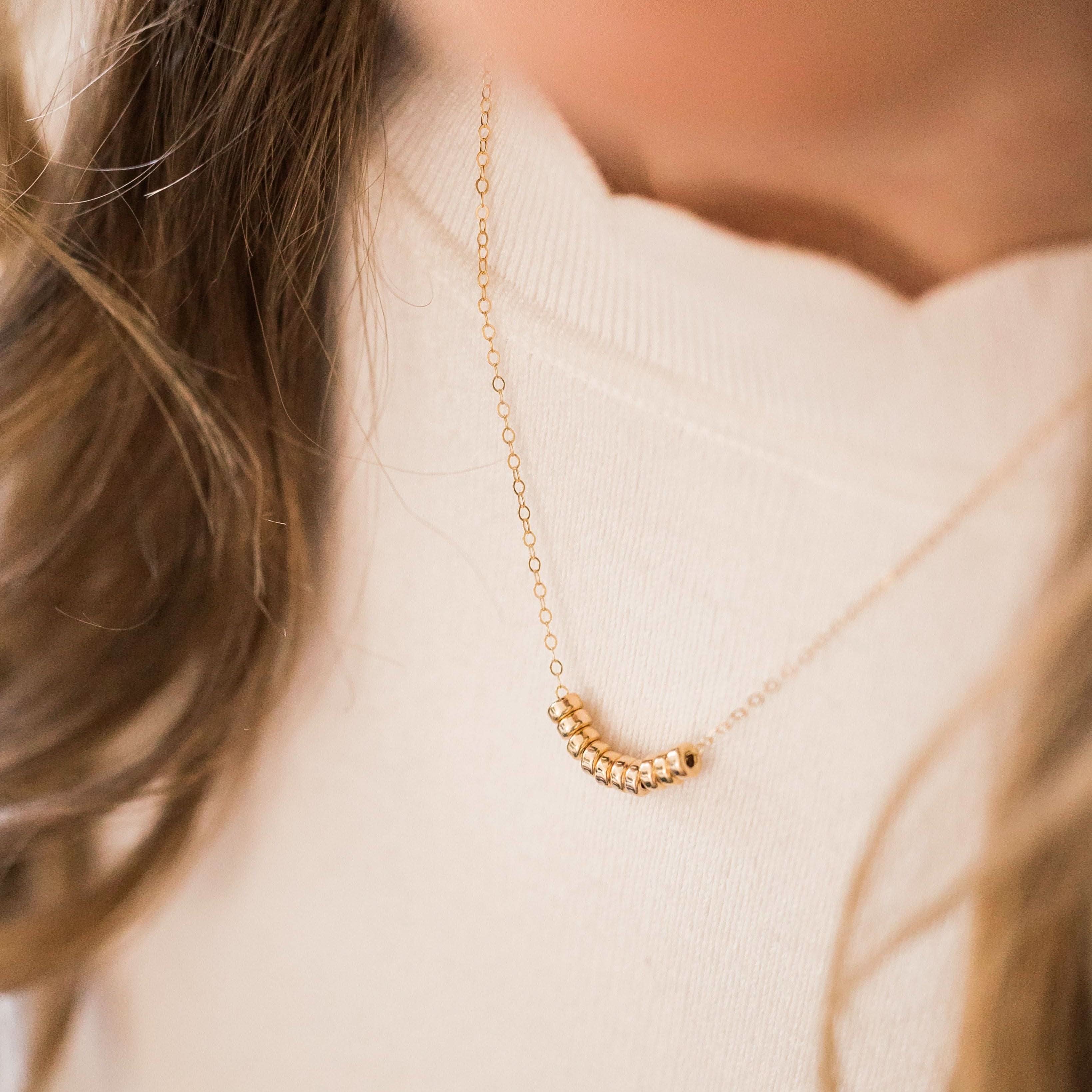 Barberry & Lace Roundel Bead Necklace worn on model, showcasing minimalist gold beads for a refined and stylish jewelry look.