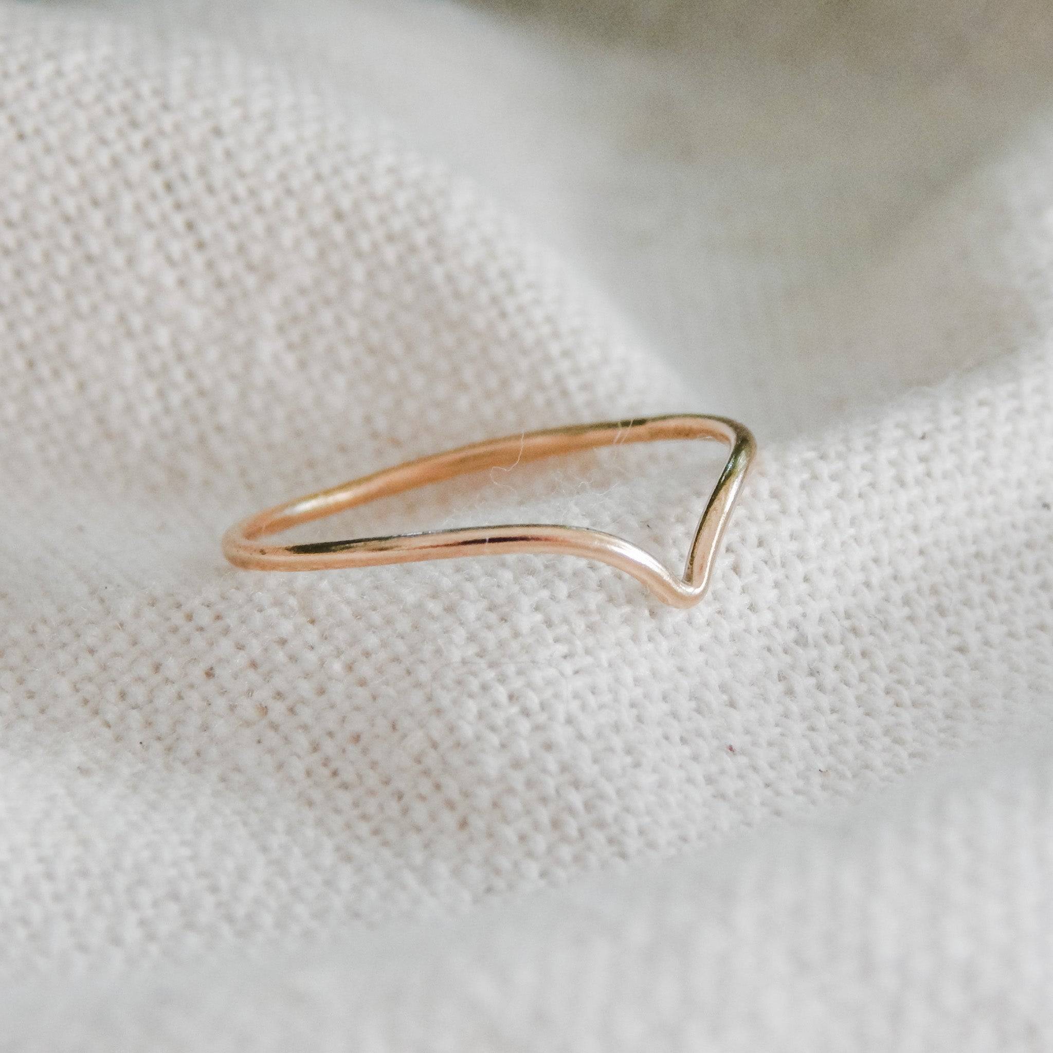 Close-up of Chevron Stacking Ring in 14k Gold Fill by Barberry & Lace Jewelry, resting on soft fabric to highlight its sleek V-shape.