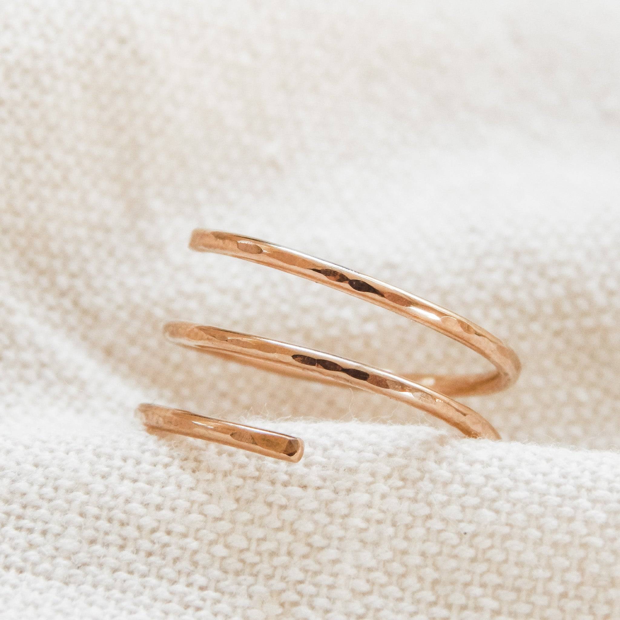 Stylish Waterproof Hammered Wrap Ring in 14k Gold Fill resting on textured fabric, perfect for a bold yet minimal jewelry statement.