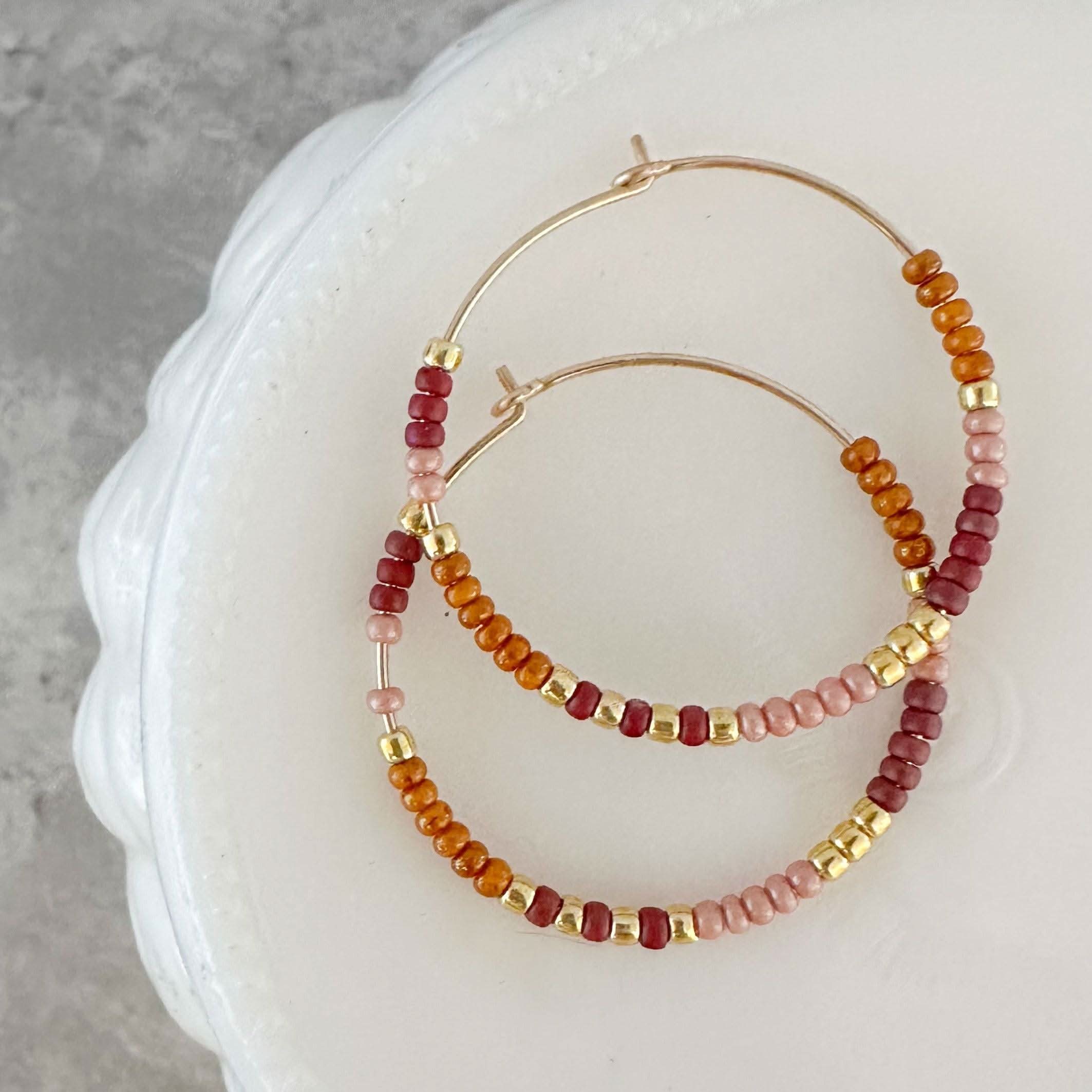 Holiday Edition - Beaded Hoop Earrings in Mulled Cider with warm red, amber, and gold beads. Cozy and stylish for seasonal wear.