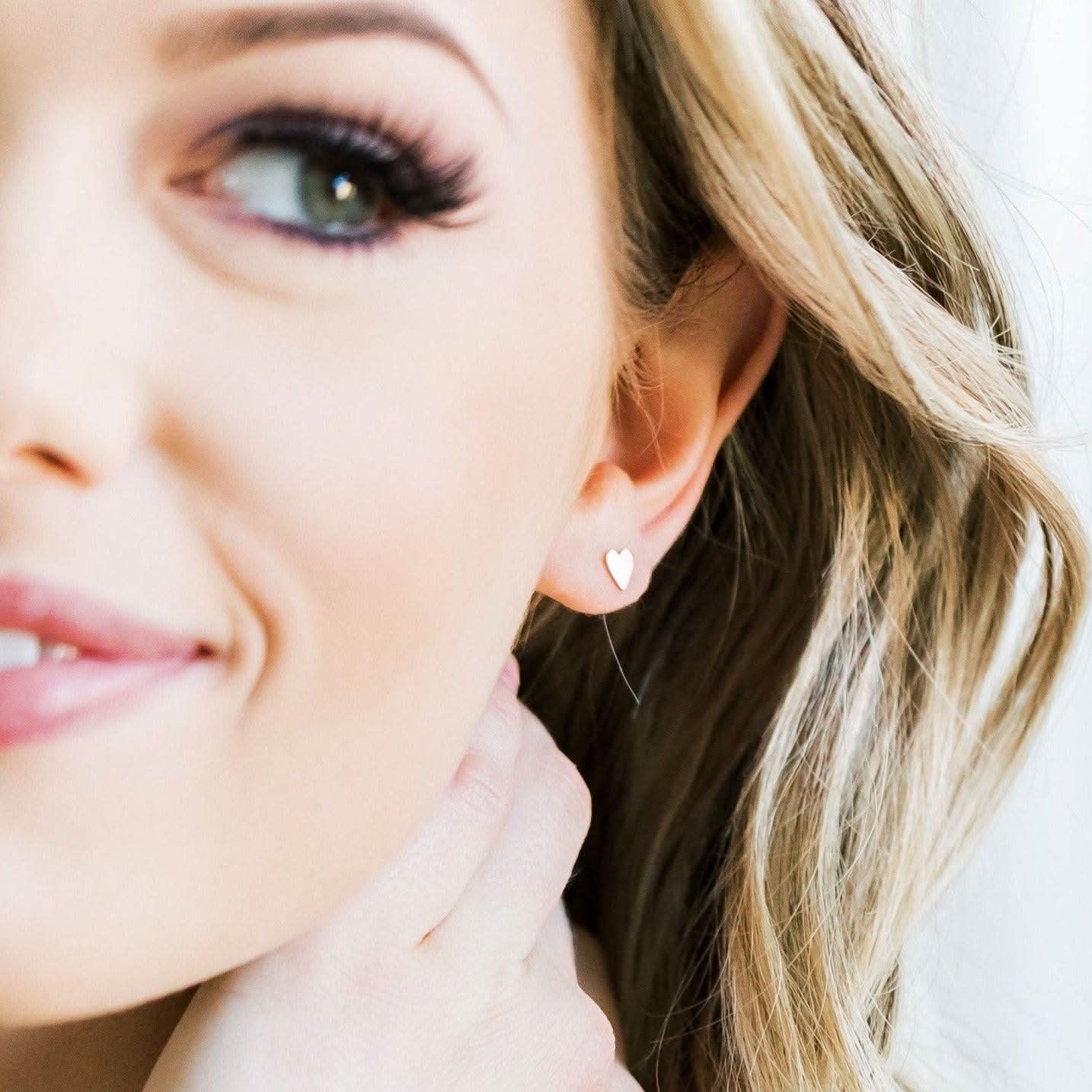 Model wearing Heart Stud Earrings from Barberry & Lace Jewelry. Minimalist gold heart studs perfect for everyday wear.