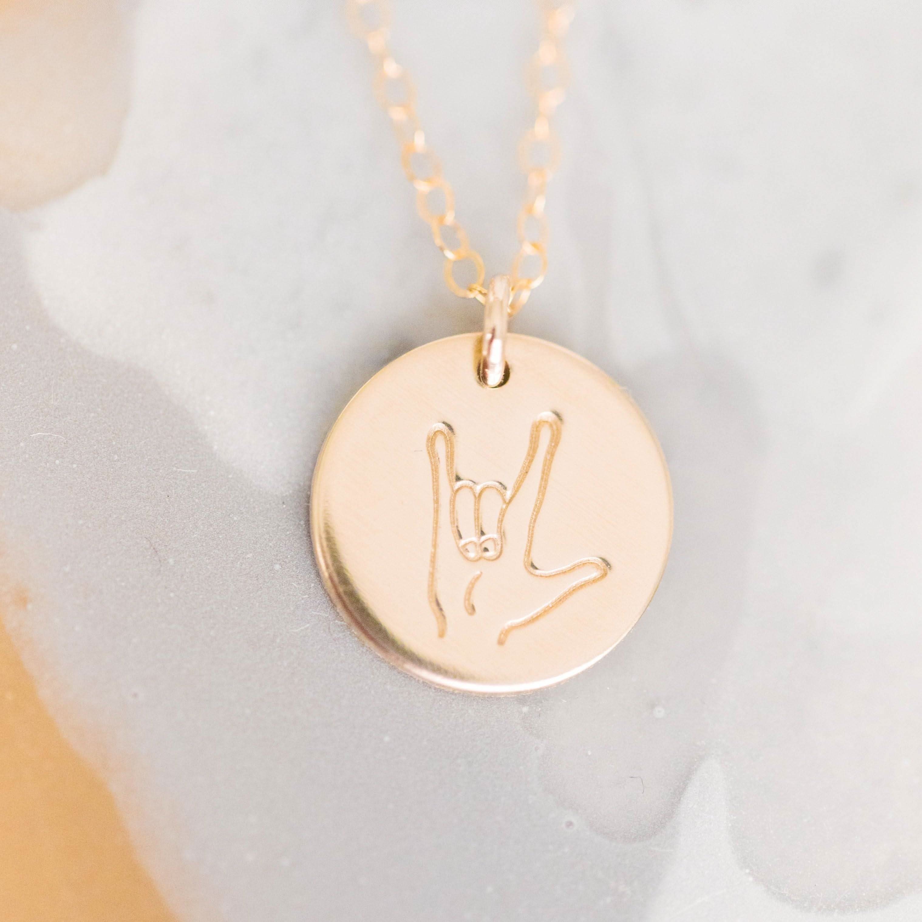 Close-up of ASL 'I Love You' Sign Language Disc Necklace in 14k gold fill with engraved hand symbol, ideal for everyday wear.