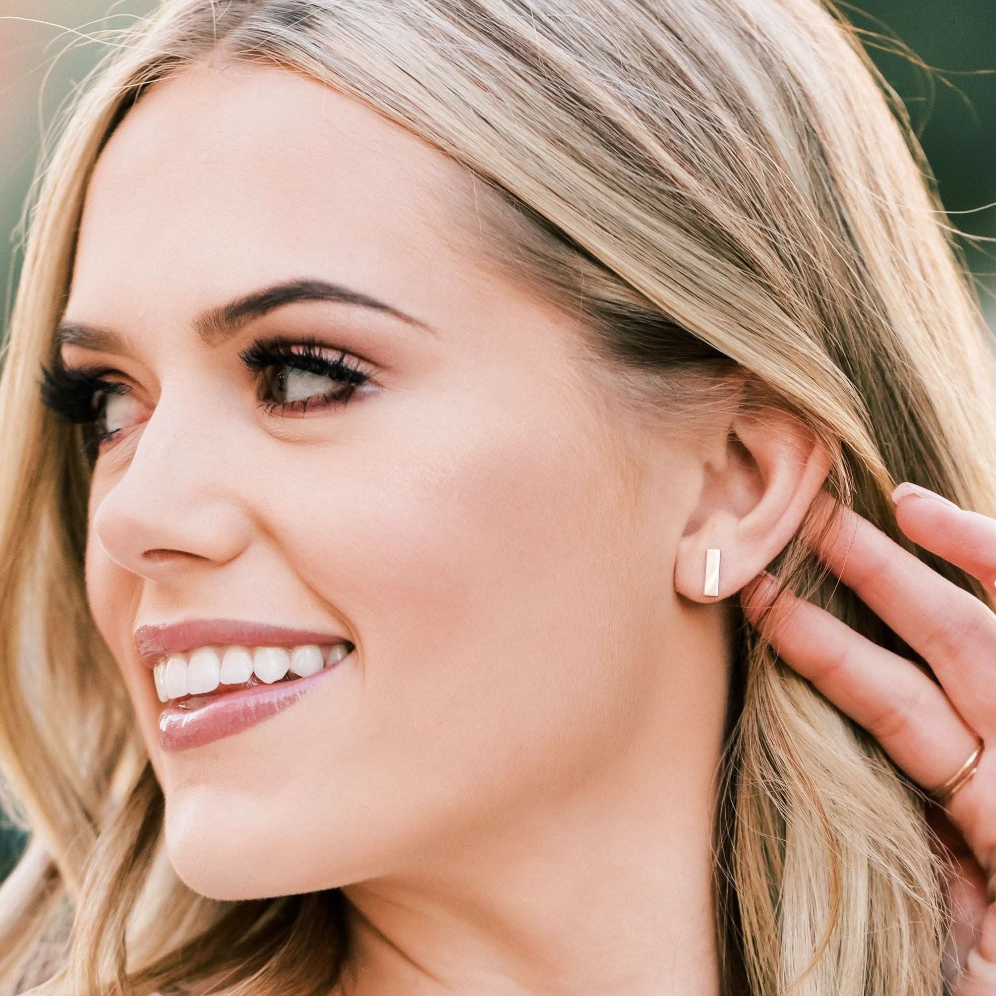 Woman wearing hypoallergenic bar stud earrings by Barberry & Lace Jewelry. Minimalist gold design perfect for daily wear and sensitive skin.