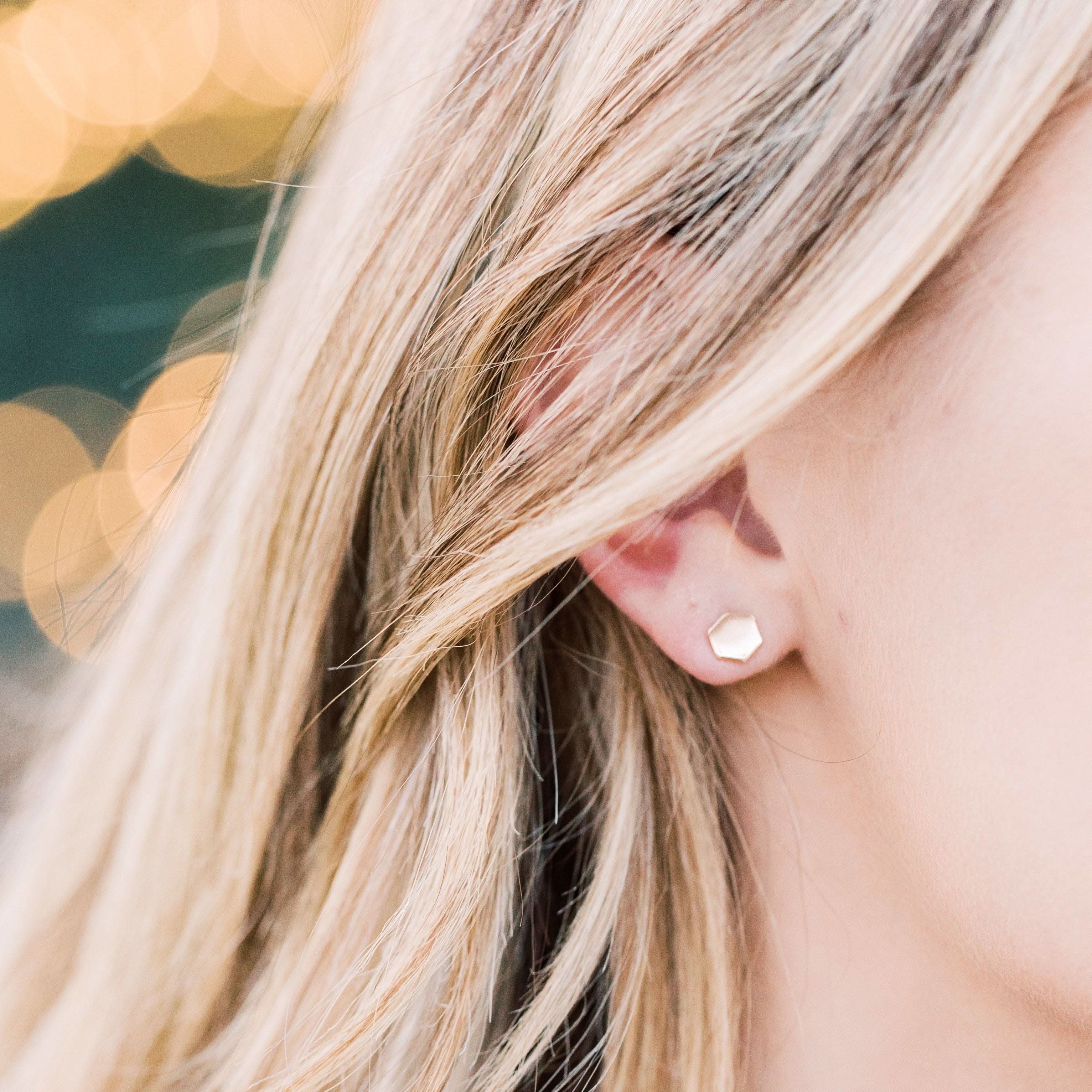 Woman wearing hypoallergenic hexagon stud earrings in gold fill. Modern minimalist jewelry perfect for sensitive ears and daily use.