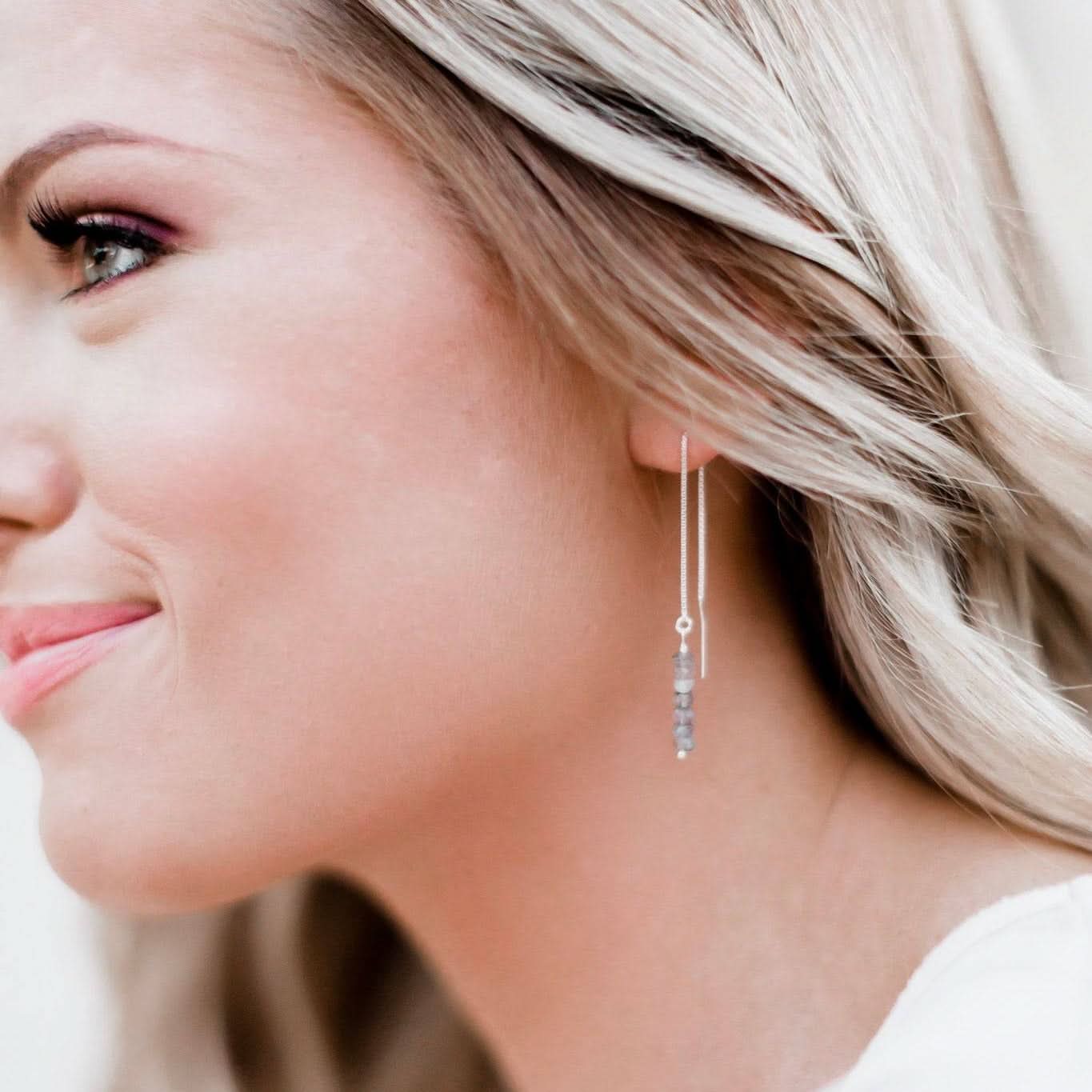 Close-up of Labradorite threaded earrings worn by a woman, highlighting the delicate chain and stacked gemstone beads in sterling silver.