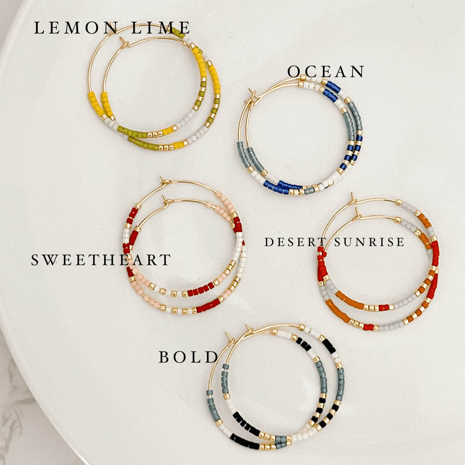 Five color options of Summer Edition - Beaded Hoop Earrings labeled Lemon Lime, Ocean, Sweetheart, Desert Sunrise, and Bold on a white plate.
