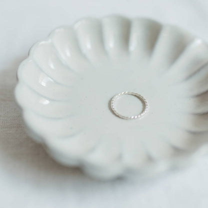 Sterling Silver Baguette Twisted Stacking Ring displayed in a scalloped ceramic dish, perfect for minimalist jewelry lovers.