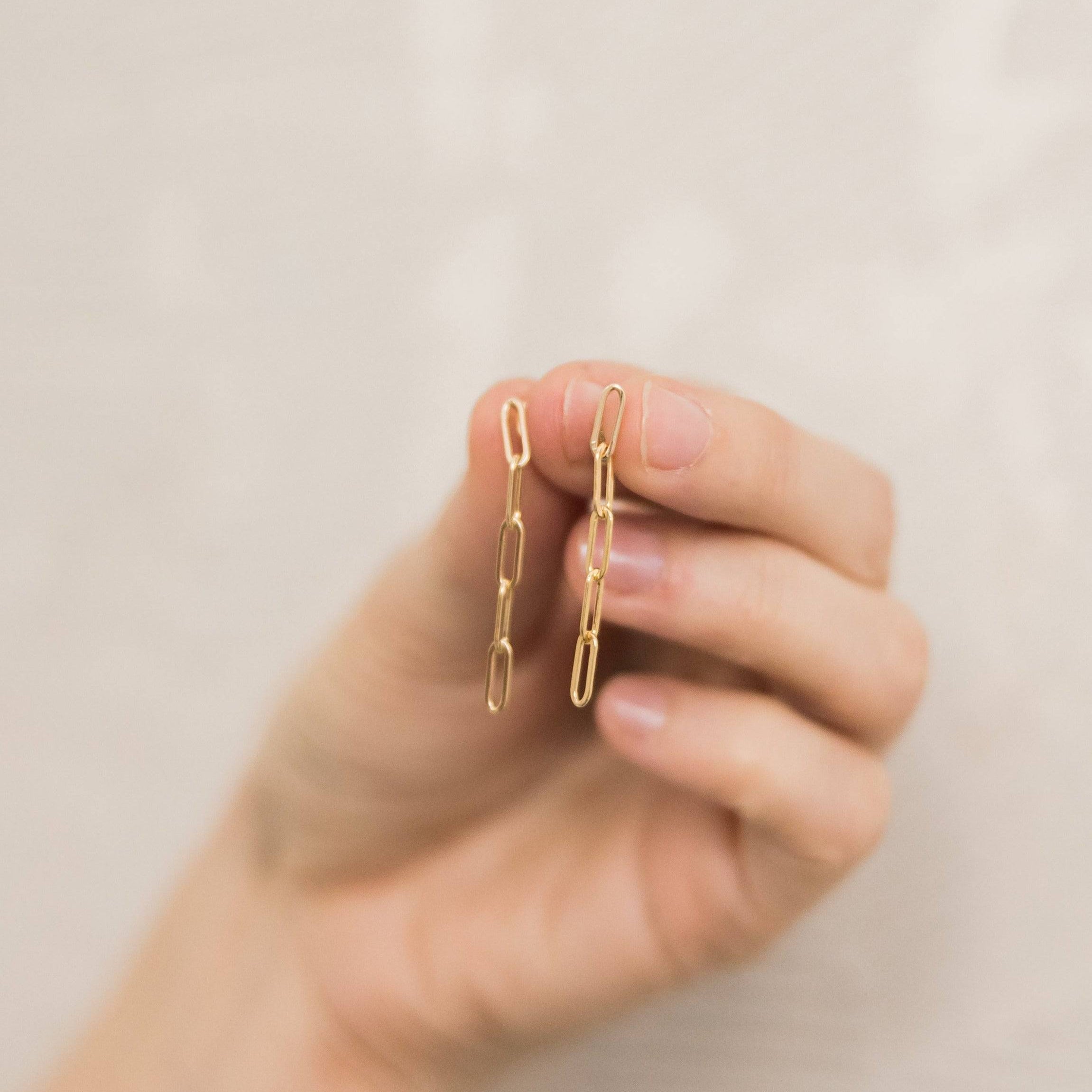 Hand holding Barberry & Lace Paperclip Stud Earrings in 14k Gold Fill, emphasizing lightweight, hypoallergenic minimalist jewelry.
