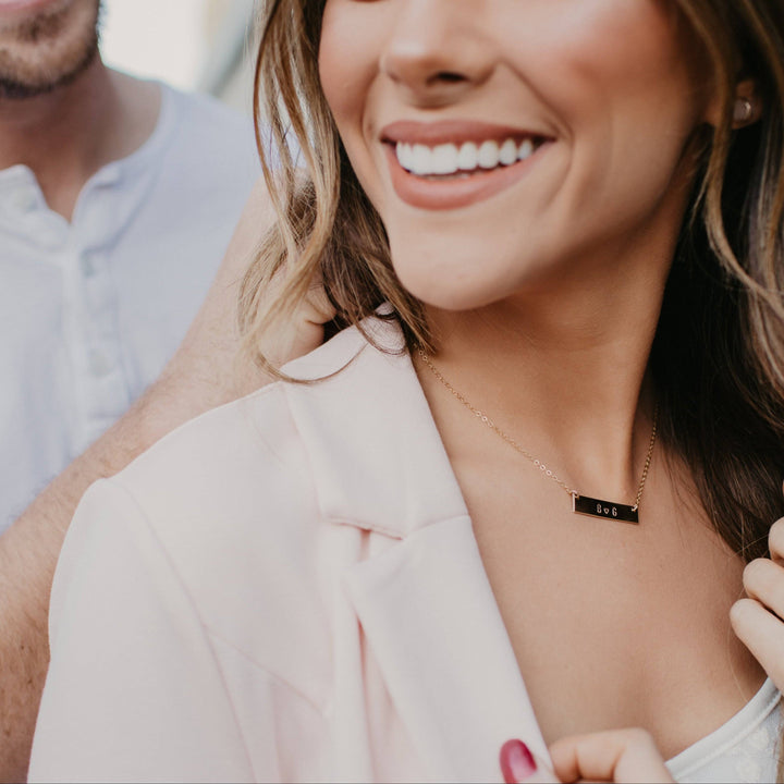 Woman wearing a Personalized Bar Necklace by Barberry & Lace Jewelry, engraved with initials, crafted in 14k Gold Fill, ideal for sensitive skin.
