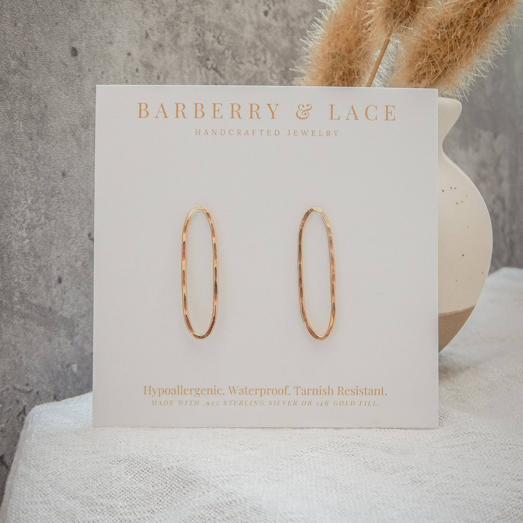 Hammered oval stud earrings on branded card with hypoallergenic and waterproof details.
