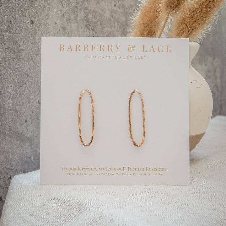 Hammered oval stud earrings on branded card with hypoallergenic and waterproof details.