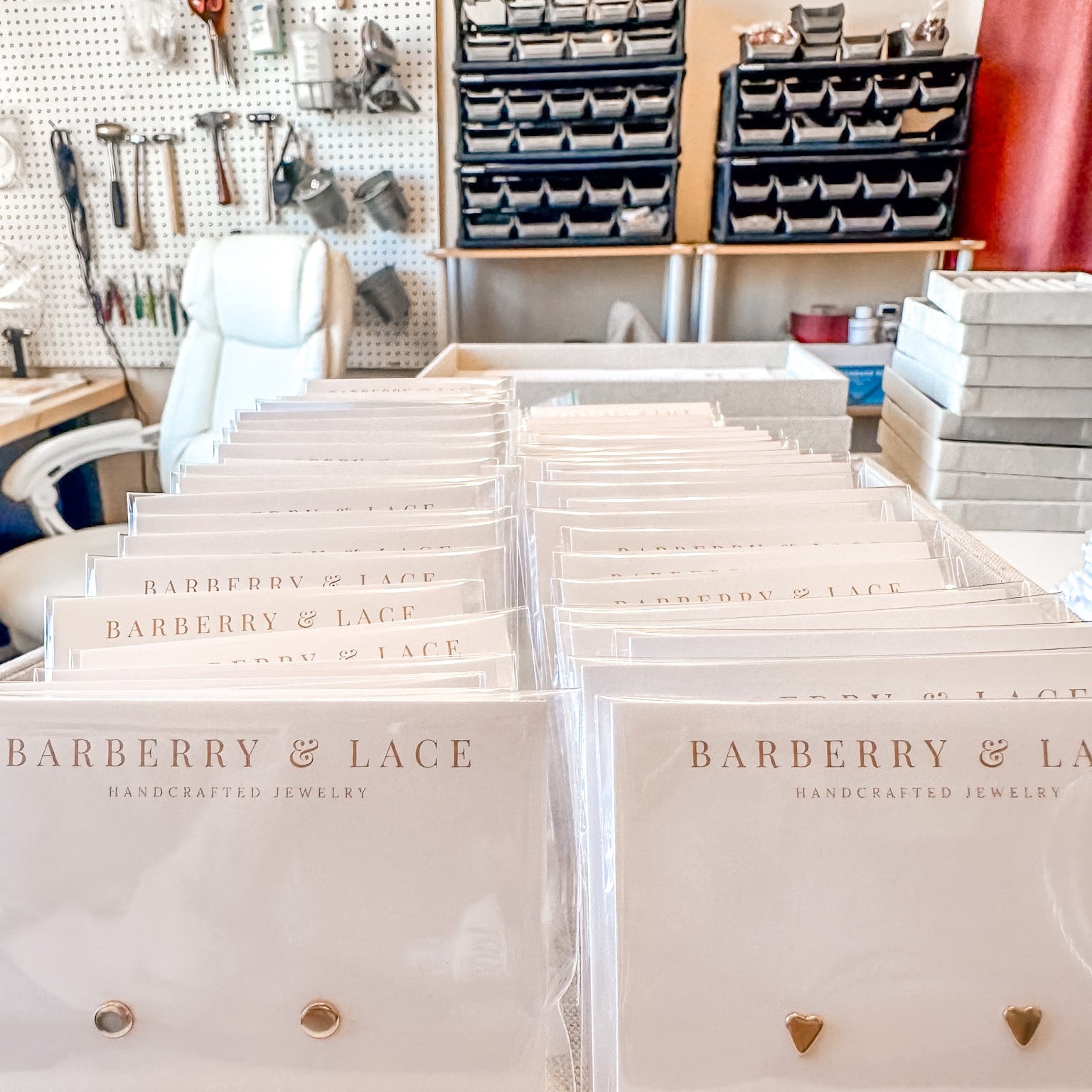 Jewelry boxes with 'Barberry & Lace' branding on a table in a workshop setting.