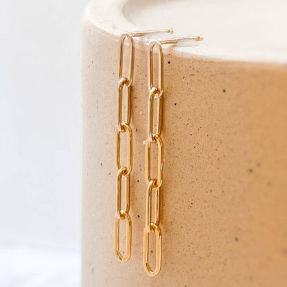 Pair of Barberry & Lace Paperclip Stud Earrings in 14k Gold Fill resting on ceramic surface, highlighting sleek, waterproof chain-link design.