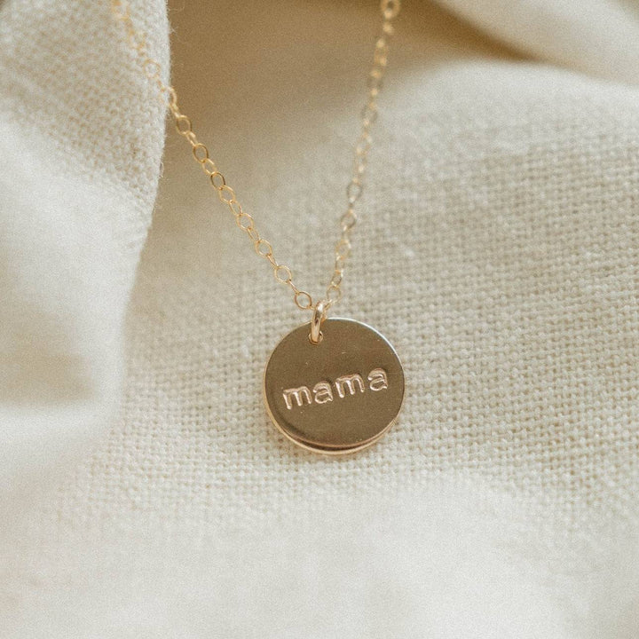 Close-up of the Mama Disc Necklace in 14k gold fill by Barberry & Lace Jewelry, featuring a delicate chain and engraved 'mama' pendant.