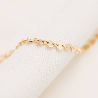 Close-up of Barberry & Lace Disc Chain Bracelet in 14k Gold Fill featuring delicate flat discs linked in a shimmering chain design.