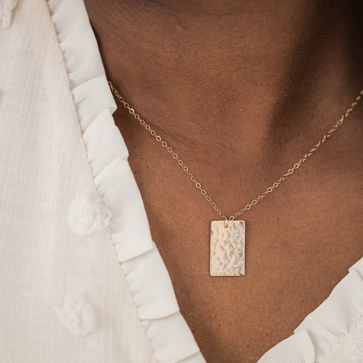 Close-up of the Hammered Rectangle Necklace worn on the neck. The gold fill pendant adds a modern, elegant touch to any outfit.