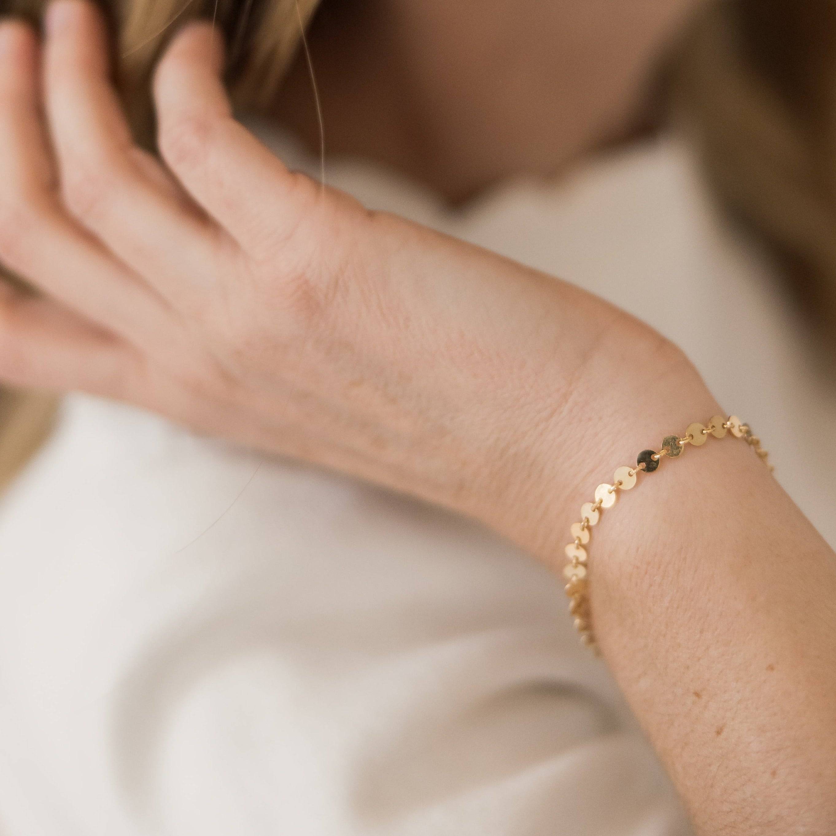Woman wearing the Barberry & Lace Disc Chain Bracelet in gold, showcasing its elegant and minimalist style for everyday jewelry wear.