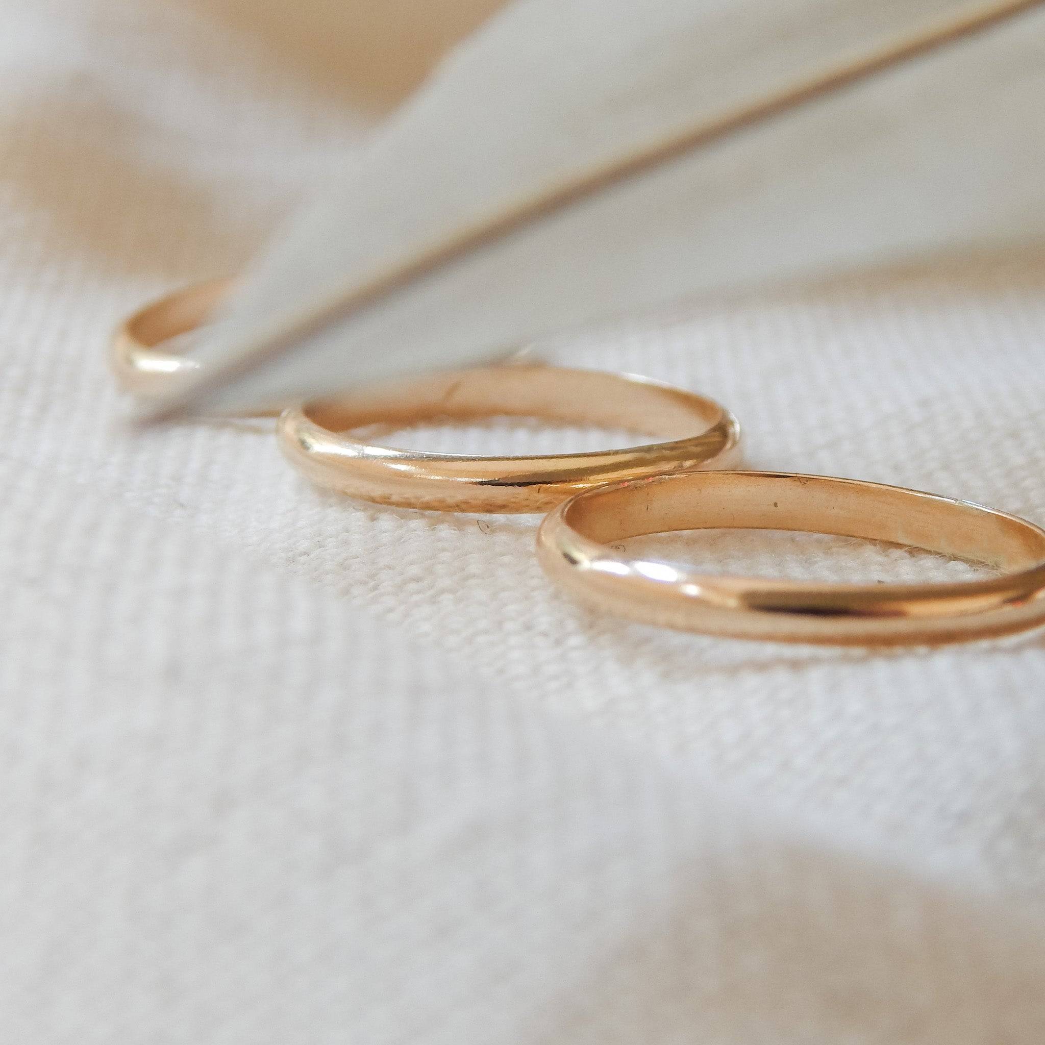 Set of three Classic Band Stacking Rings in 14k Gold Fill from Barberry & Lace Jewelry, shown on a textured fabric surface.