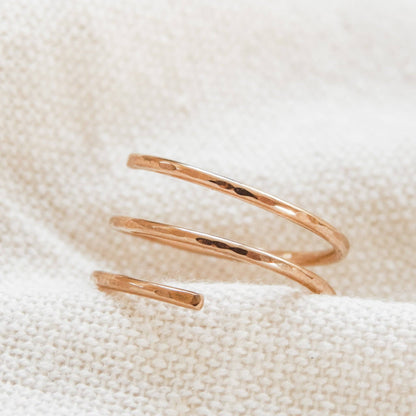 Stylish Waterproof Hammered Wrap Ring in 14k Gold Fill resting on textured fabric, perfect for a bold yet minimal jewelry statement.