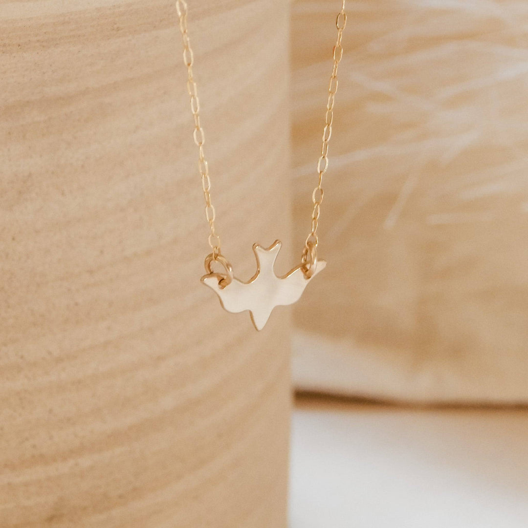Layering Soaring Bird Necklace in 14k Gold Fill with delicate chain, displayed against a neutral background for minimalist style appeal.