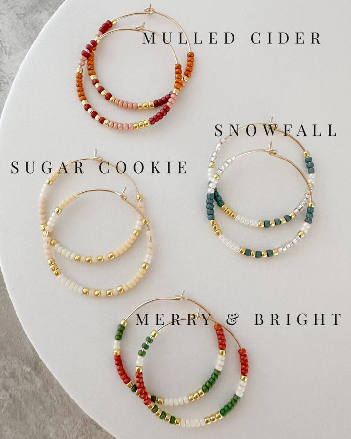 Holiday Edition - Beaded Hoop Earrings in four festive styles: Mulled Cider, Sugar Cookie, Snowfall, and Merry & Bright. Perfect holiday accessories.