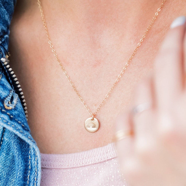 Barberry & Lace hand stamped rainbow disc necklace worn on model, showcasing minimalist gold charm on fine chain. Ideal for everyday wear.
