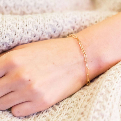 Minimalist gold Paperclip Chain Bracelet worn on wrist, showcasing its delicate design ideal for layering and daily styling.
