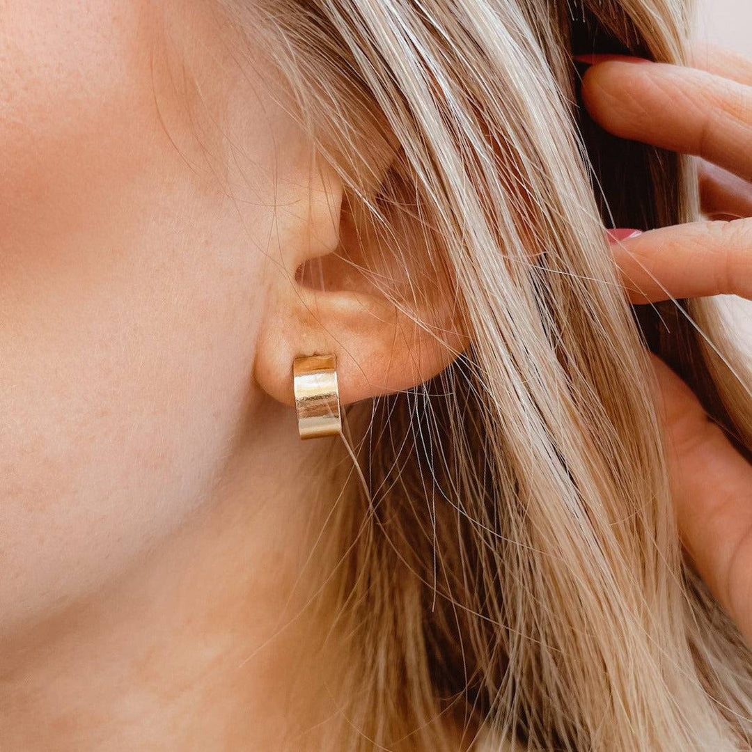 Model wearing Thick Huggie Hoop Stud Earrings in gold fill, demonstrating their everyday wearability and bold, minimalist look.