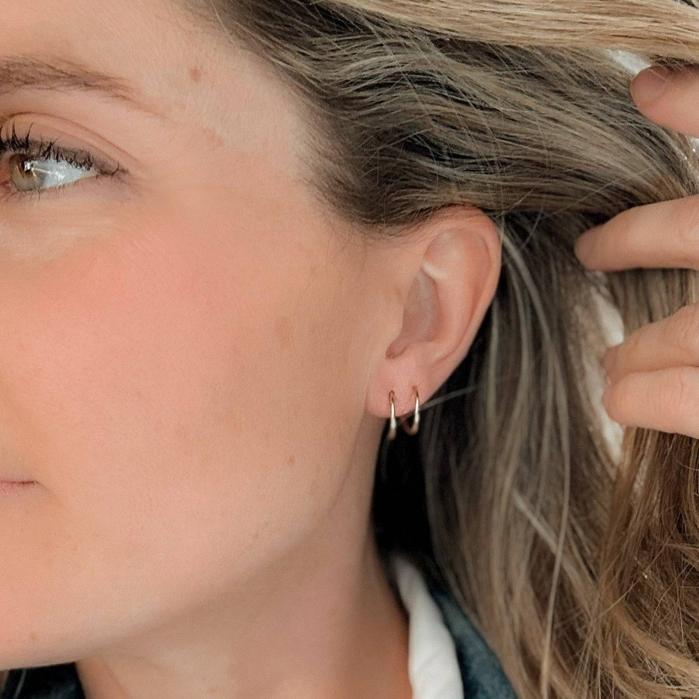 Model wearing Twist-In Double Huggie Hoop Earrings by Barberry & Lace Jewelry, showcasing the elegant double hoop effect on the ear.