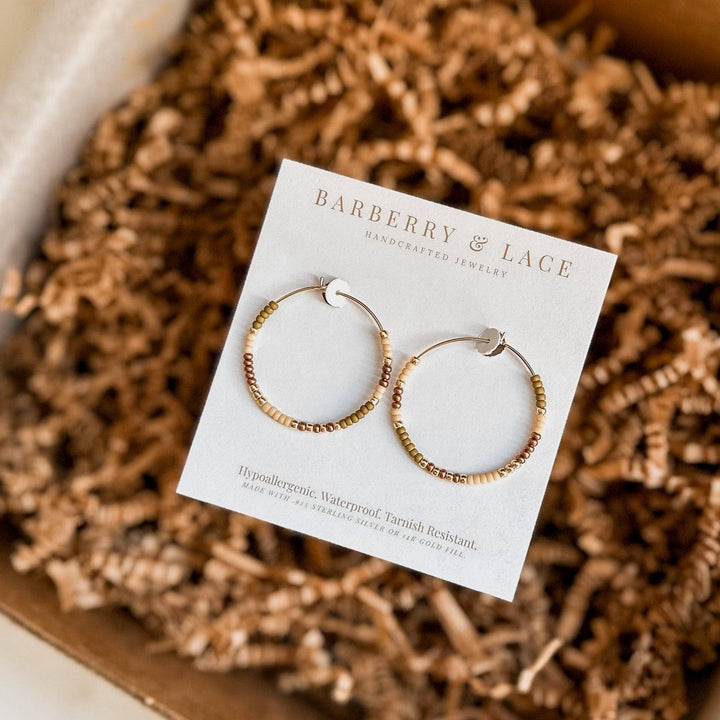 Holiday Edition - Beaded Hoop Earrings displayed on Barberry & Lace card with gold and bronze beads. Waterproof and tarnish-resistant gift option.
