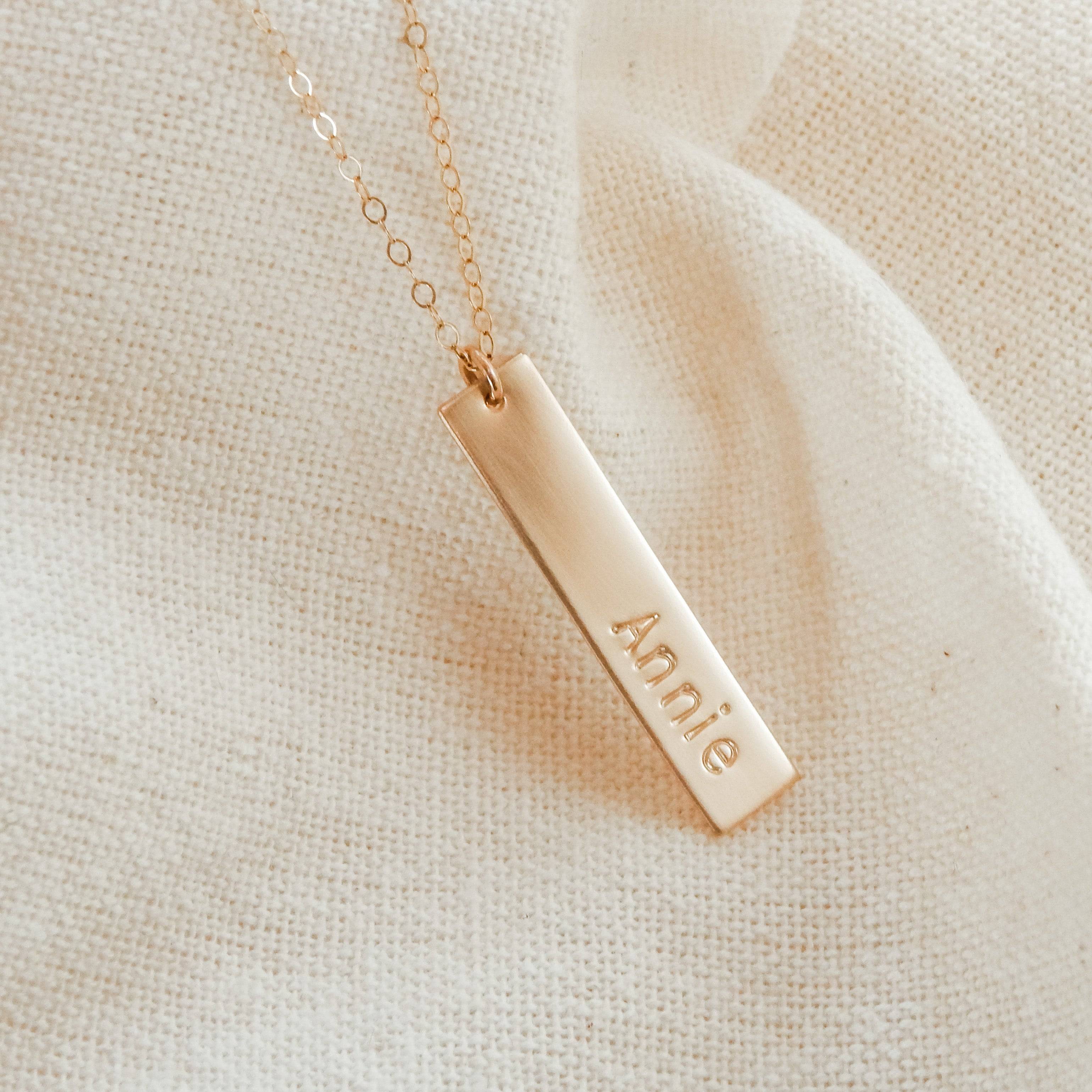 Personalized Vertical Bar Necklace by Barberry & Lace Jewelry featuring a gold bar engraved with 'Annie' on a delicate chain, ideal for gifting.