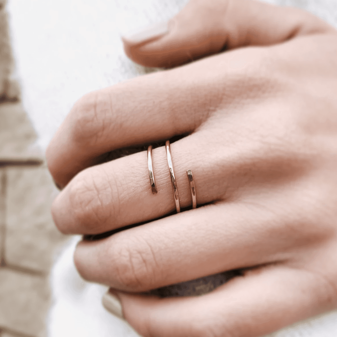Hand wearing the Waterproof Hammered Wrap Ring in 14k Gold Fill, paired with other minimalist rings for a layered jewelry look.