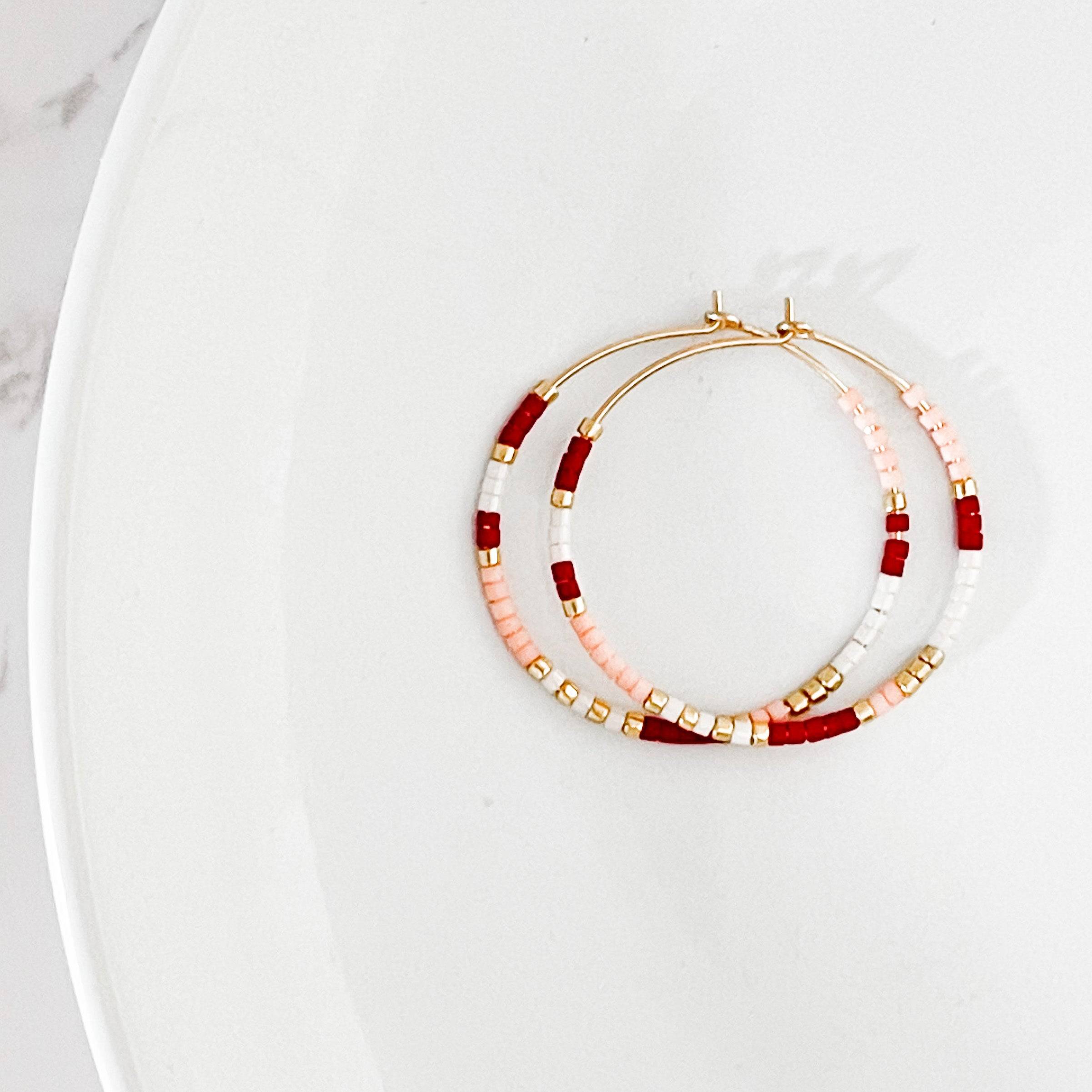 Close-up of Sweetheart colorway from Summer Edition - Beaded Hoop Earrings, featuring pink, red, white, and gold seed beads on gold hoops.