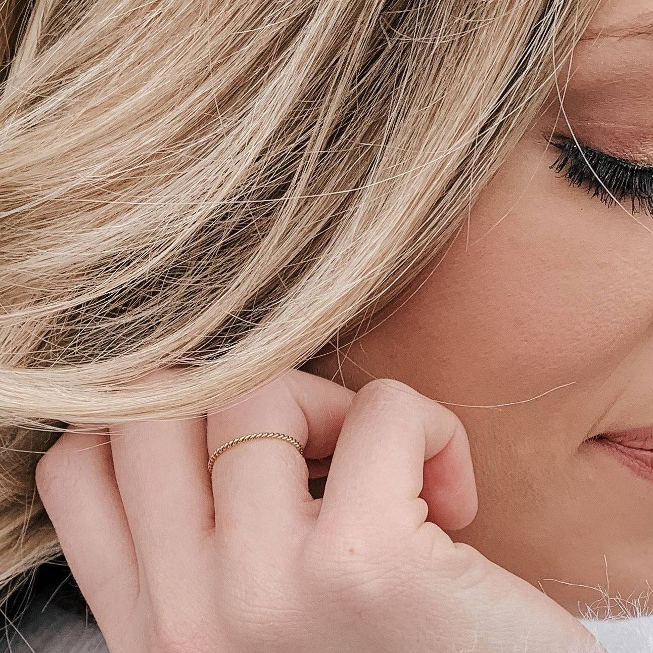 Woman wearing the Petite Twisted Stacking Ring on her finger, showcasing its delicate and minimalist style for daily wear.