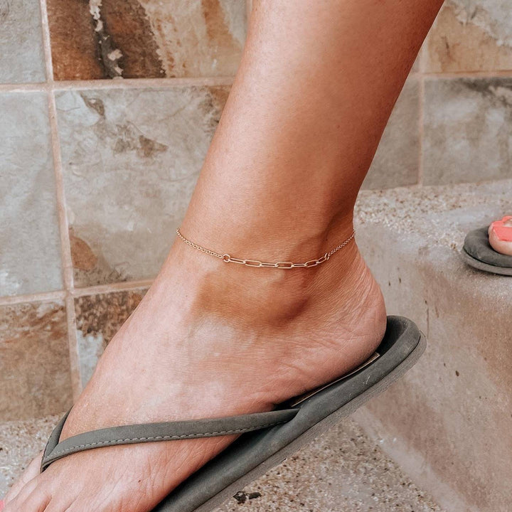 Paperclip Chain Anklet in 14k Gold Fill by Barberry & Lace Jewelry, worn on ankle with flip-flops. Minimalist, waterproof, and hypoallergenic design.