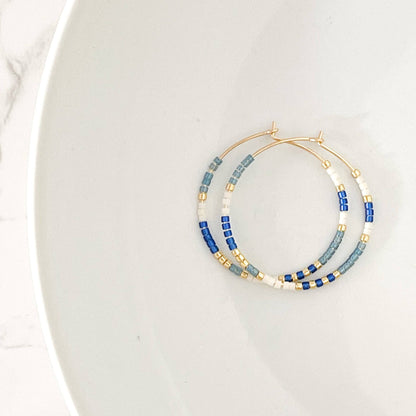 Ocean colorway of Summer Edition - Beaded Hoop Earrings featuring blue, white, and gold seed beads on gold hoops, styled on a white background.