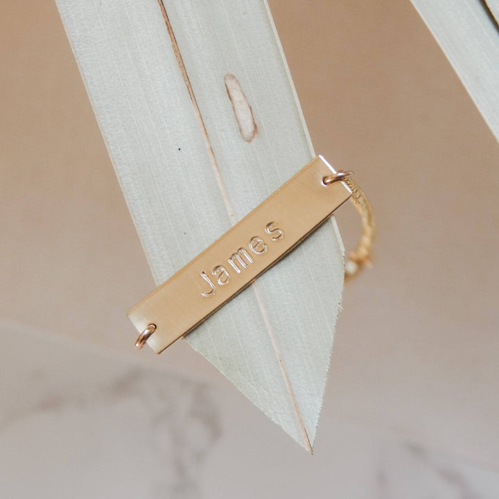 Personalized Bar Bracelet by Barberry & Lace Jewelry featuring a gold bar engraved with 'James', ideal for custom gifts and everyday wear.