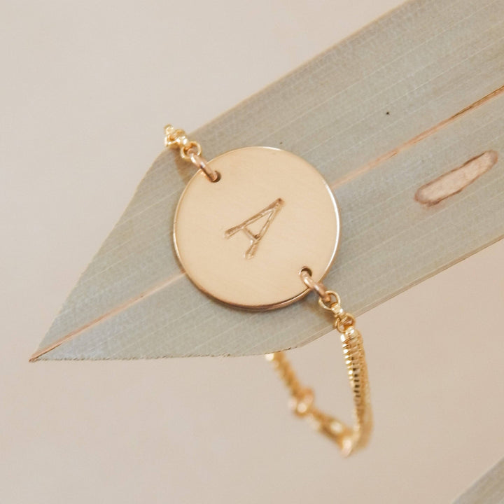 Personalized Disc Bracelet by Barberry & Lace Jewelry featuring a hand-stamped initial 'A' on a 14k gold fill disc with a delicate chain. Perfect for everyday wear.